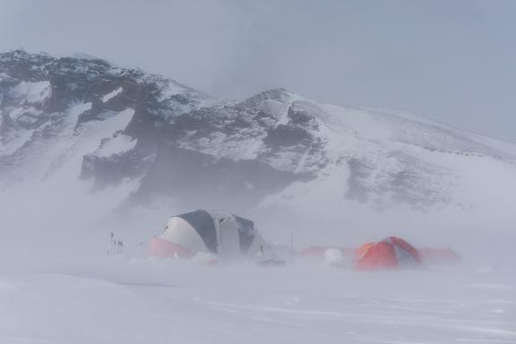 Tents and blowing snow at Mount Sidley base camp, in the Weiss Amphitheater (caldera).